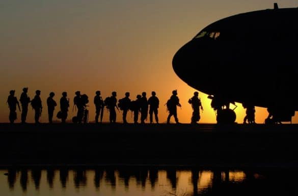 A line of soldier walk up to an aircraft
